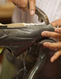 Cobbler mending sole of shoe